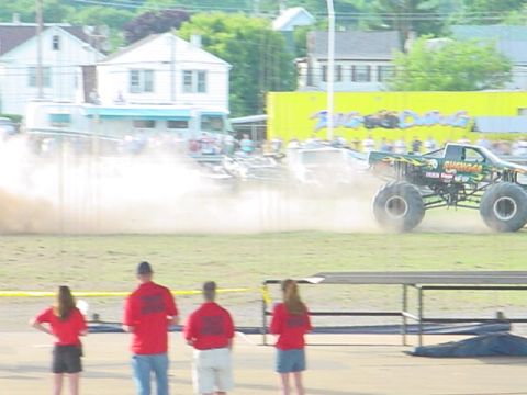 1979 Ford Bronco - Monster truck event with multiple vehicles and spectators in the background.