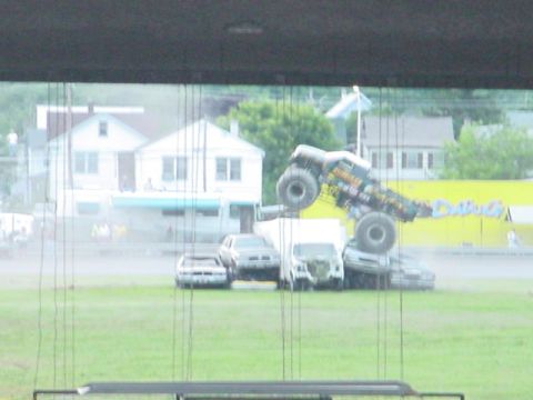 1979 Ford Bronco - A monster truck is shown crushing several cars during an event.
