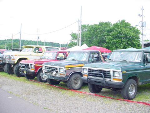1979 Ford Bronco - Several Ford trucks and SUVs are parked in a row, with a green truck in the foreground.