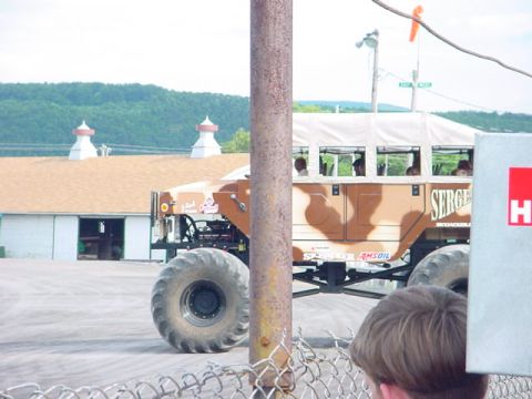 1979 Ford Bronco - A modified monster truck with a bus body, carrying passengers, is seen outdoors near some buildings.