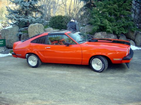1978 Ford Mustang II - This 1978 Ford Mustang II coupe features a bright orange paint job with black racing stripes and custom wheels.