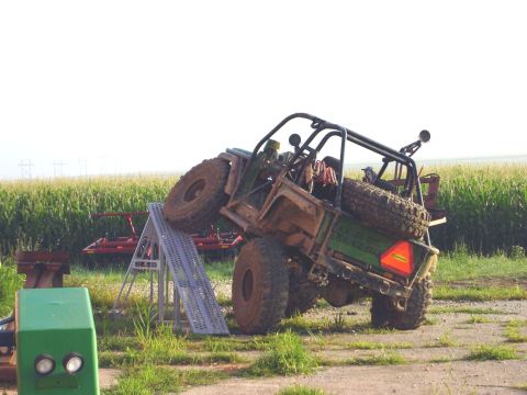 1992 Ford Bronco - A modified off-road vehicle is positioned on a ramp, with a cornfield in the background.