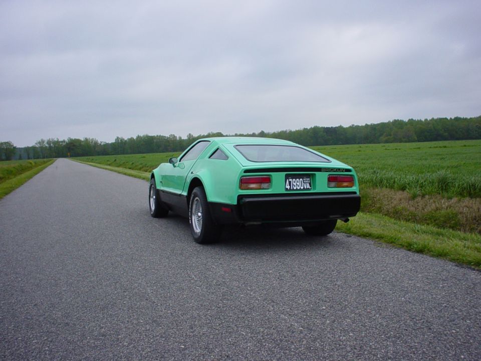 Green Bricklin coupe seen from rear on a rural road, Virginia plate 47990VA.