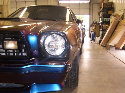 1978 Ford Mustang II - The front corner of a 1978 Ford Mustang II displays a unique iridescent paint job.
