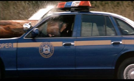 1991 Ford Crown Victoria LTD - Police car side view with a log impacting the windshield and water spraying.