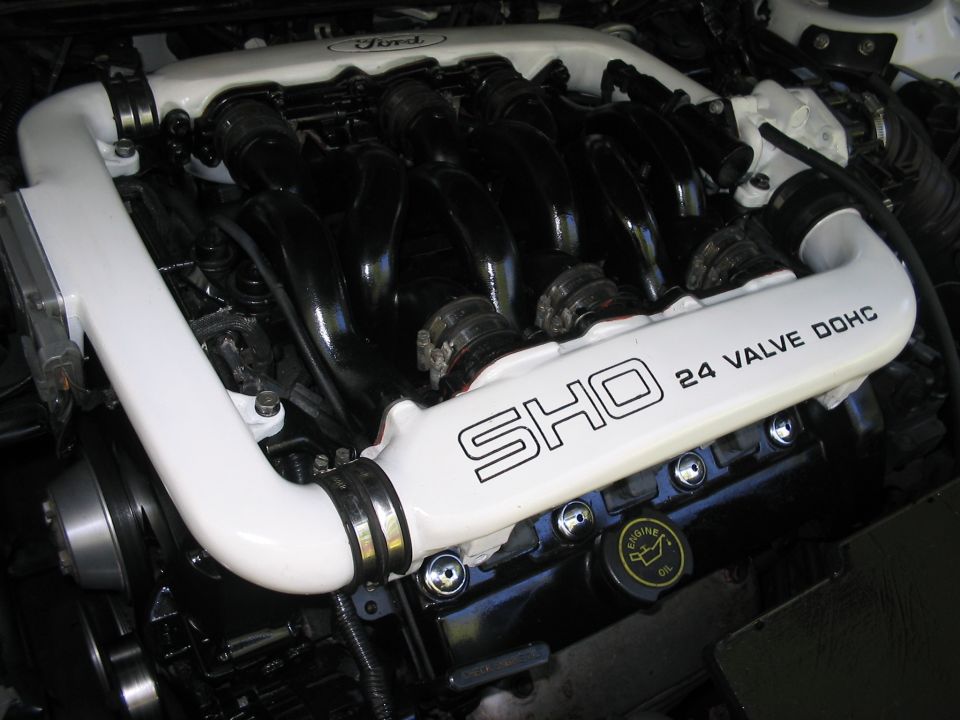 Close-up of a Ford SHO 24 valve DOHC engine with white intake manifolds