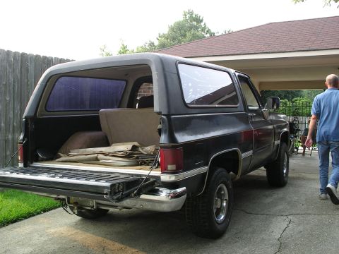 1984 Chevrolet Blazer - This black SUV, likely a 1973 model, is shown from the rear with its tailgate open.