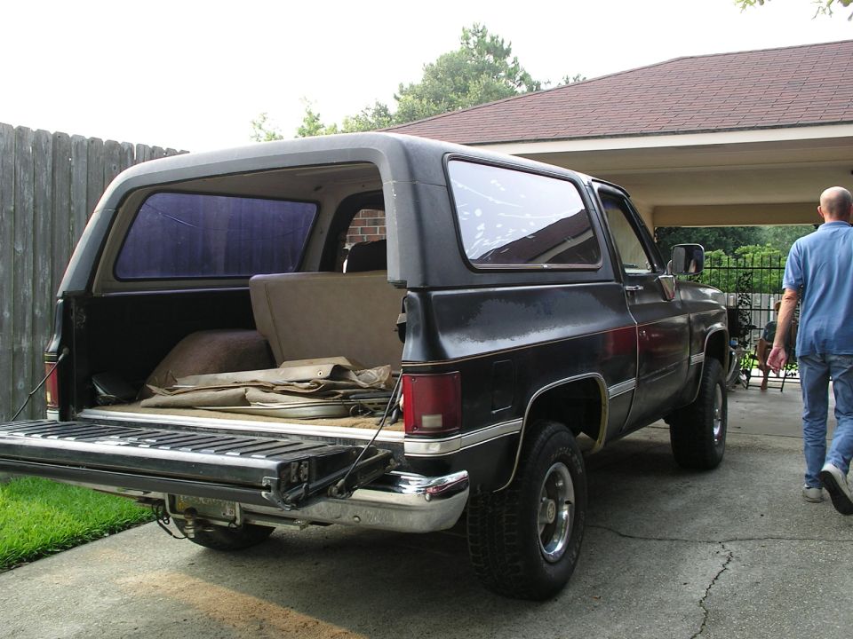 Black and maroon square-body Chevy K5 Blazer with tailgate down and rear glass removed