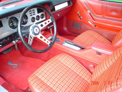 1978 Ford Mustang II - The interior of a 1978 Ford Mustang II features red carpeting and plaid upholstery.