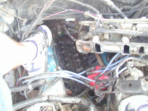 1988 Ford Bronco - A foot is placed on the engine block, obscuring some of the engine components.