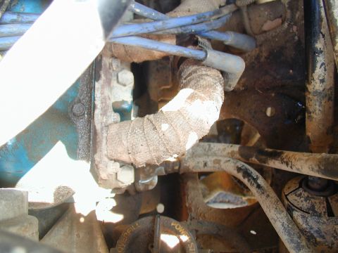 1988 Ford Bronco - A close-up view of engine components, including spark plug wires and a heat-wrapped exhaust pipe.