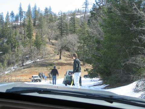 1989 Ford Bronco - Several SUVs navigate a snowy, wooded landscape during an offroad excursion.