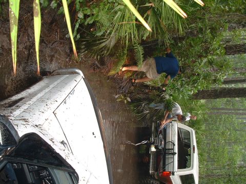 1995 Ford Bronco - Two SUVs are stuck in the mud while people attempt to get them out.