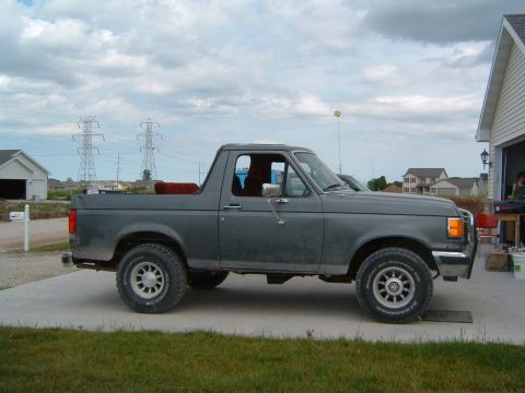 1987 Ford Bronco - This 1987 Ford Bronco is shown from the side, its gray exterior and red interior.