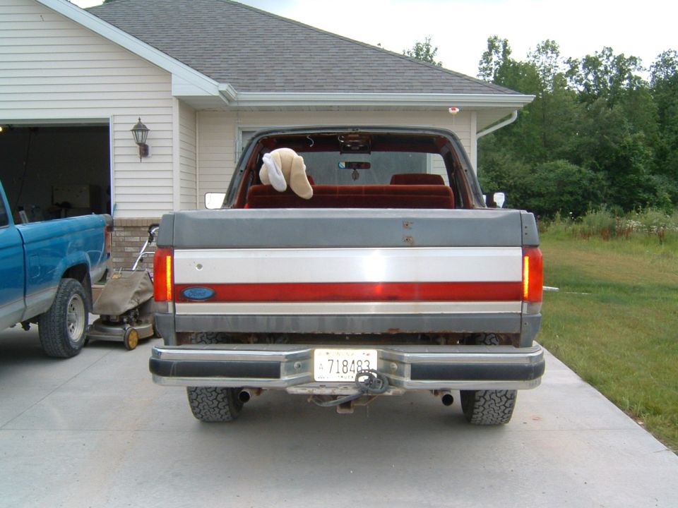 1987 Ford Bronco rear view, grey and red stripe tailgate, license plate 718483