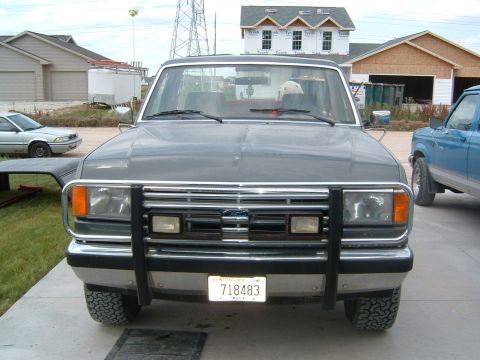 1987 Ford Bronco - Front view of a 1987 Ford Bronco, with a bull bar and another Ford Bronco in the background.