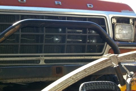 1978 Ford Bronco - Close-up of a Ford truck's front end, a prominent grille and a protective bull bar.
