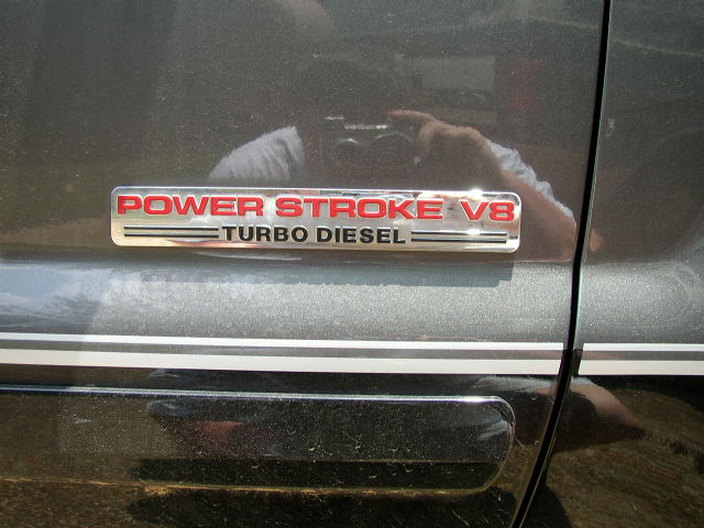 Chrome and red Power Stroke V8 Turbo Diesel badge on a dark gray vehicle door