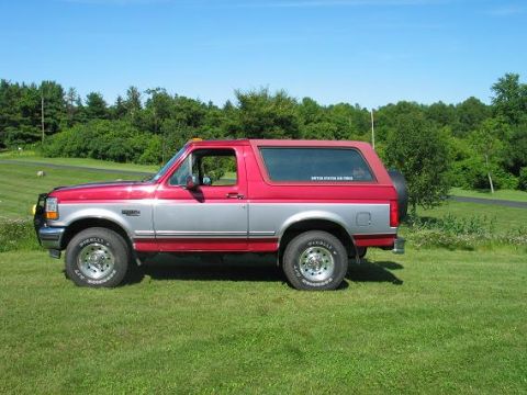 1995 Ford Bronco - This two-tone 1995 Ford Bronco is parked on a grassy lawn under a clear blue sky.