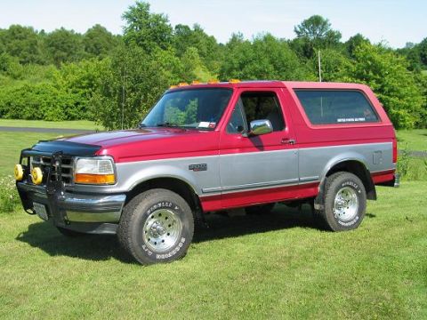 1995 Ford Bronco - This 1995 Ford Bronco is parked on a grassy lawn with trees in the background.