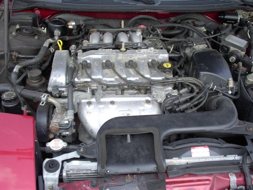 Ford four-cylinder engine bay viewed from front, valve cover reading Ford