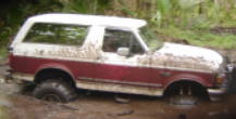 1993 Ford Bronco - This 1993 Ford Bronco is deep in the mud, with its front right wheel completely submerged.