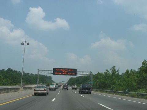 1988 Ford Bronco - Traffic moves along a highway with an electronic sign warning about air quality.