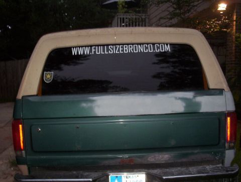 1989 Ford Bronco - The rear of a 1989 Ford Bronco shows a website sticker and a Texas license plate.