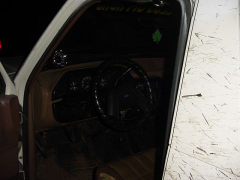 1989 Ford Bronco - Interior view of a 1989 Ford Bronco, showing the dashboard, steering wheel, and tan seating. An aftermarket gauge is visible on the A-pilla…