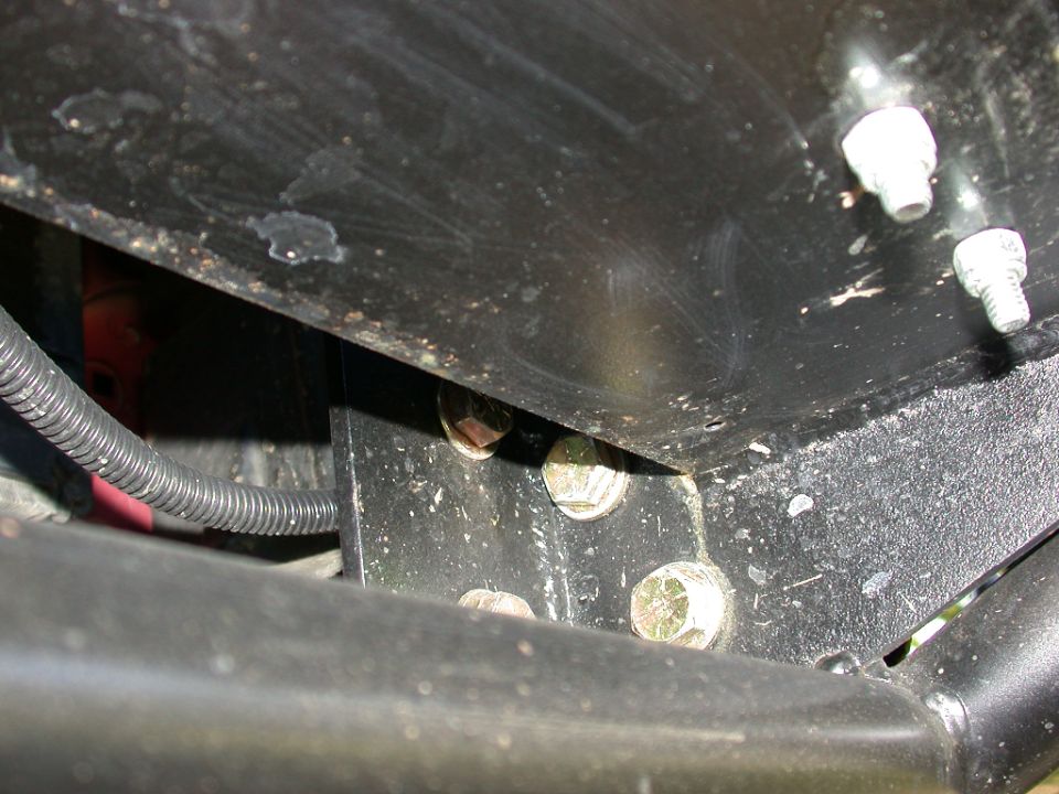 Black steel bracket bolted to a frame with zinc-plated hardware and wiring loom