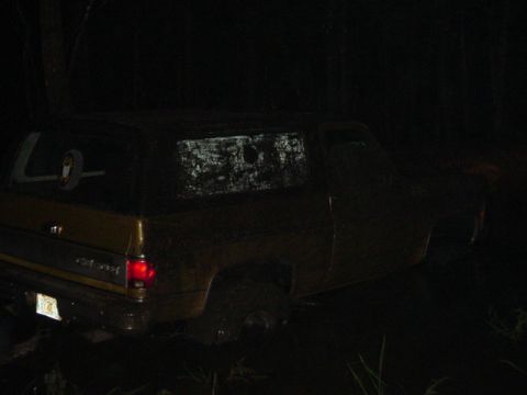 1989 Ford Bronco - This vehicle appears to be stuck in mud during nighttime conditions.