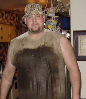 1989 Ford Bronco - A man stands indoors wearing a stained shirt and a camouflage hat.