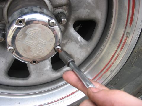 1988 Ford Bronco - Servicing a manual locking hub on a wheel, with a socket wrench in use.