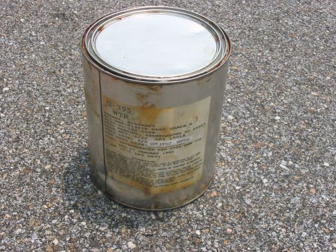 1988 Ford Bronco - A metal can labeled G-395 WTR, with a test date of January 1982, sits on a gravel surface.