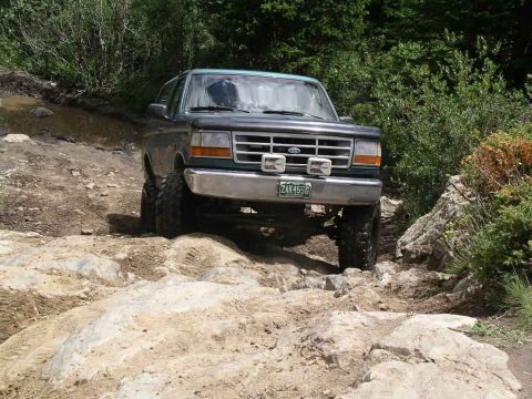 1996 Ford Bronco - This 1996 Ford Bronco is tackling a difficult rocky trail, showing its off-road capability.