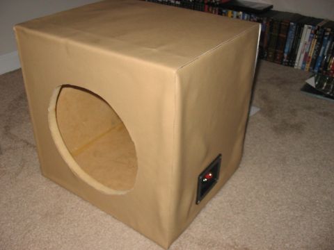 1988 Ford Bronco - Speaker box with a circular cutout and a terminal cup, sitting on carpet.