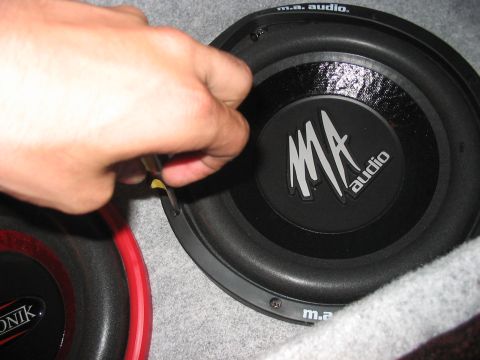 1988 Ford Bronco - A hand is shown adjusting an MA audio speaker, with another speaker partially visible.