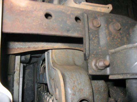 1988 Ford Bronco - This image shows a close-up view of the rusty frame and suspension parts of a vehicle, with no clear identifying features.