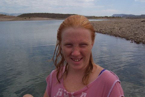 1992 Ford Bronco - Woman enjoys a day at Lake Pleasant with calm water and distant hills under a cloudy sky.