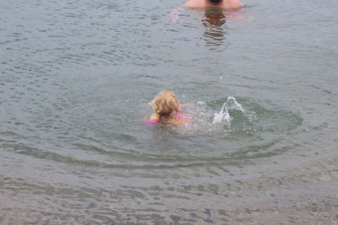 1992 Ford Bronco - A child splashes in the water while an adult swims nearby.