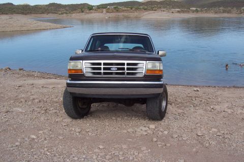1992 Ford Bronco - This 1992 Ford Bronco is parked on a rocky shore next to a body of water.