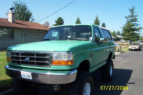 1996 Ford Bronco - This lifted green 1996 Ford Bronco is parked on a residential street.