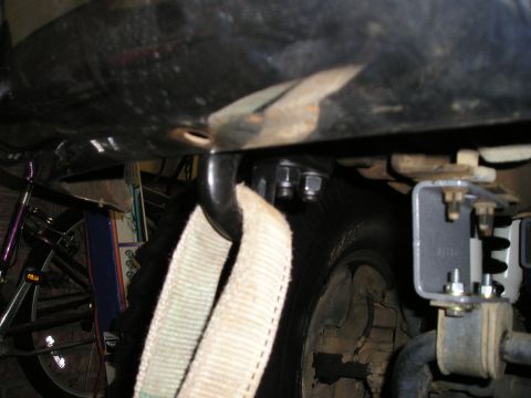 1996 Ford Bronco - Close-up view of a tow hook and strap attached to a vehicle's frame, with a tire in the background.