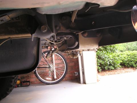 1996 Ford Bronco - Close-up view of a vehicle's undercarriage, focusing on tow points, with a bicycle visible in the background.