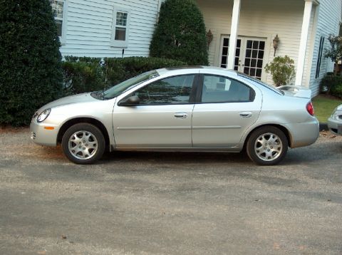 1998 Ford Taurus - This silver sedan, viewed from the side, features a prominent spoiler and appears to be from around the year 2000.