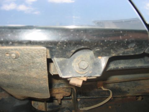 1988 Ford Bronco - Close-up view of the undercarriage of a vehicle, revealing mounting hardware and wiring.