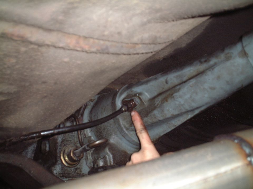 This is where the speedometer sensor goes into the tranny.  If you get larger tires or differnet gearing, you just need to swap out the gear that's attached to this cable.  Removing this cable from the tranny is as simple as unbolting one bolt.  Pretty easy.