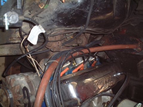 1967 Ford Galaxie - The engine bay of a vehicle is shown with various components including the alternator and spark plug wires.