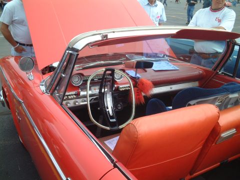 1967 Ford Galaxie - Interior of a red convertible, possibly a 1958 model, with a blue card on the dashboard.