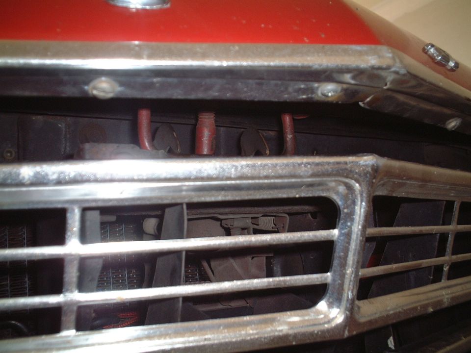 This bar/handle should latch onto the spring-loaded hooks behind the grill.